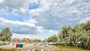 A beach with beach umbrellas and a tent. - Apartamente Sea View (Navodari)
