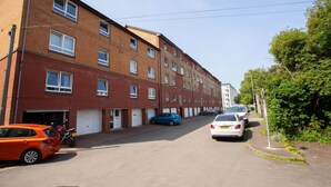 Une rangée d’immeubles d’habitation en briques rouges, avec de nombreux étages et de nombreuses fenêtres.