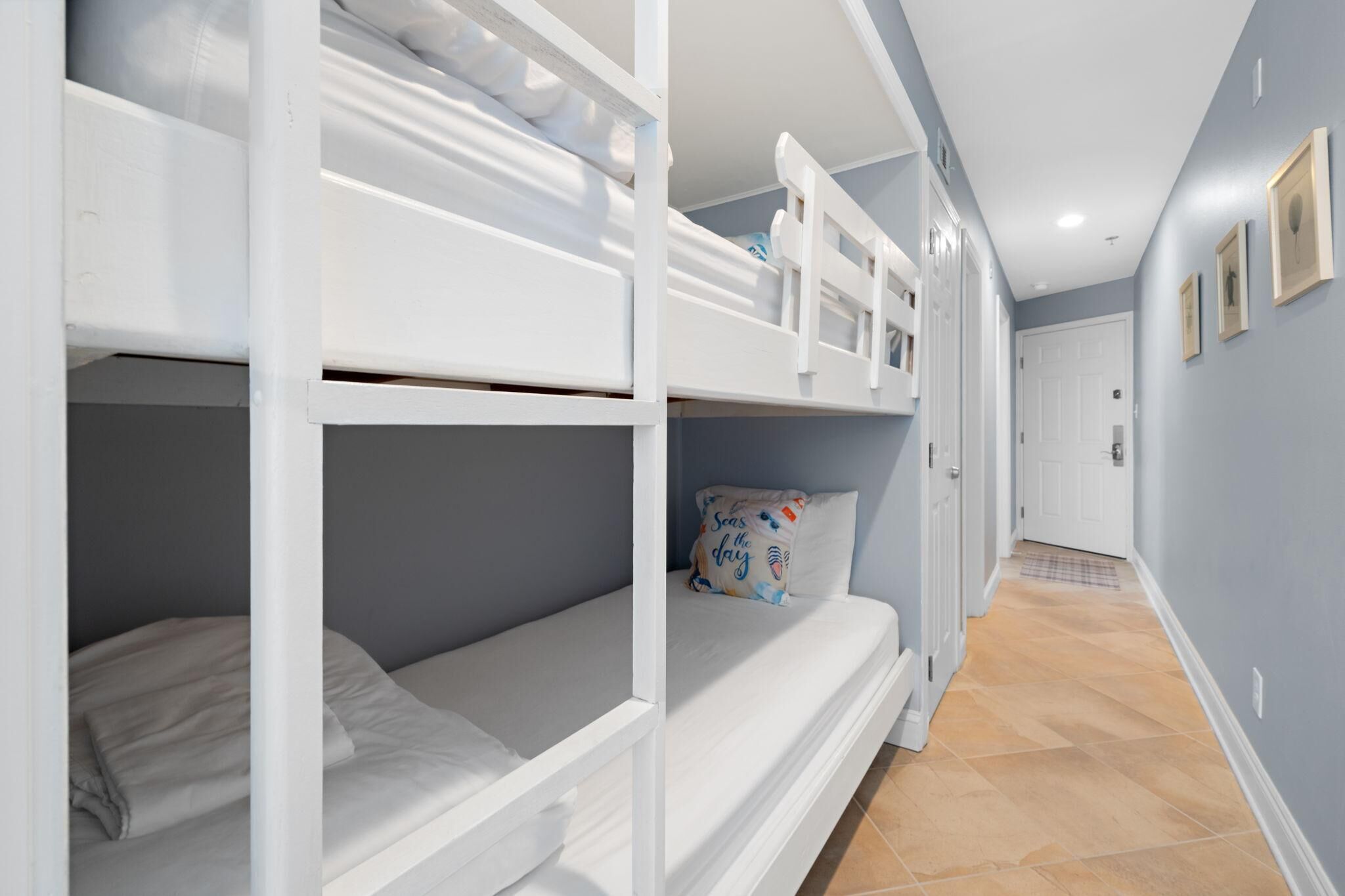 A bunk bed room with a hallway leading to a door.