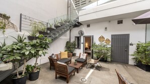 Uma área externa moderna para relaxar, com escada, assentos e plantas em vasos.