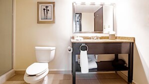 A bathroom with a toilet, a sink with a mirror above it, and a towel rack. - Studio Coliving (Panama City)
