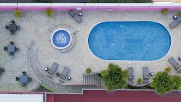 Una piscina al aire libre, sillones reclinables de piscina