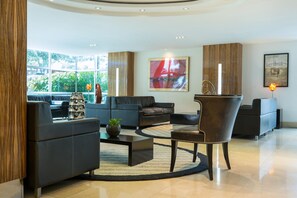 A modern living room with leather sofas, a coffee table, and a decorative vase.