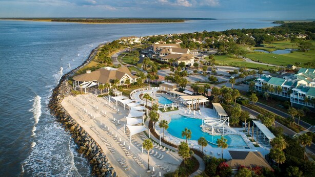 An aerial view of a coastal resort with a large pool, beach area, and multiple buildings. - Stunning Gem! Amazing Marsh/Tidal Views. Amenity access included! (Seabrook Island)