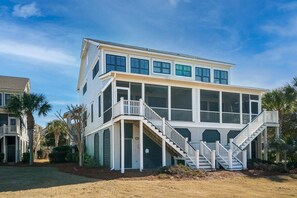 A two-story house with a balcony and a staircase leading to the entrance.