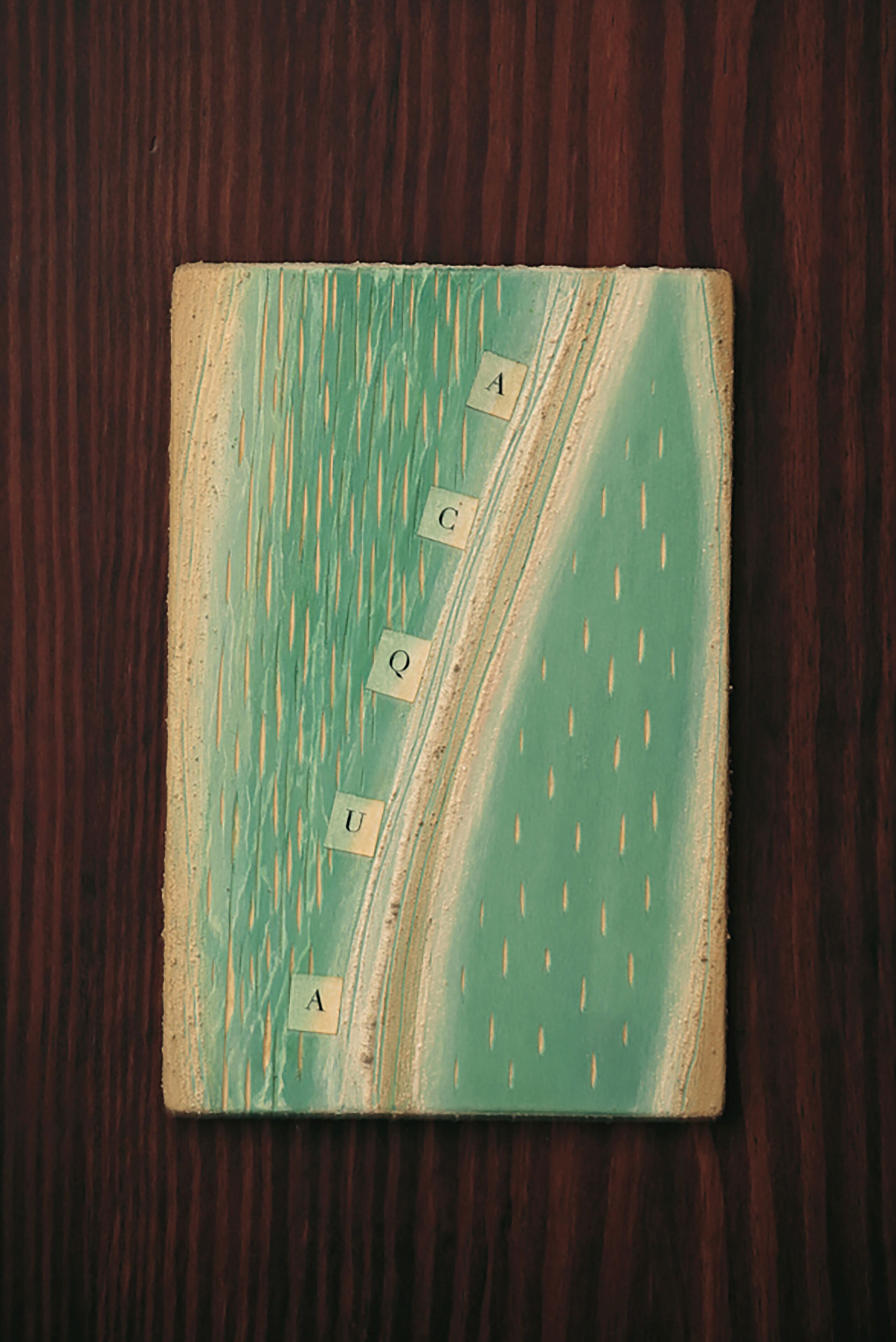A square object with a textured surface and a pattern of letters on it.