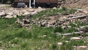 A two-story wooden cabin with a front door, a small porch area, and a grill. - Big Hole Valley cabin near river access (Wise River)