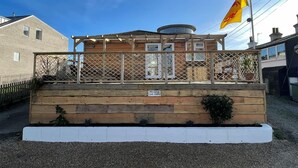 Un bâtiment à deux étages doté d’une terrasse en bois et d’un drapeau.
