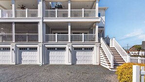 Un edificio de varios pisos con balcones, una escalera y puertas de garaje.
