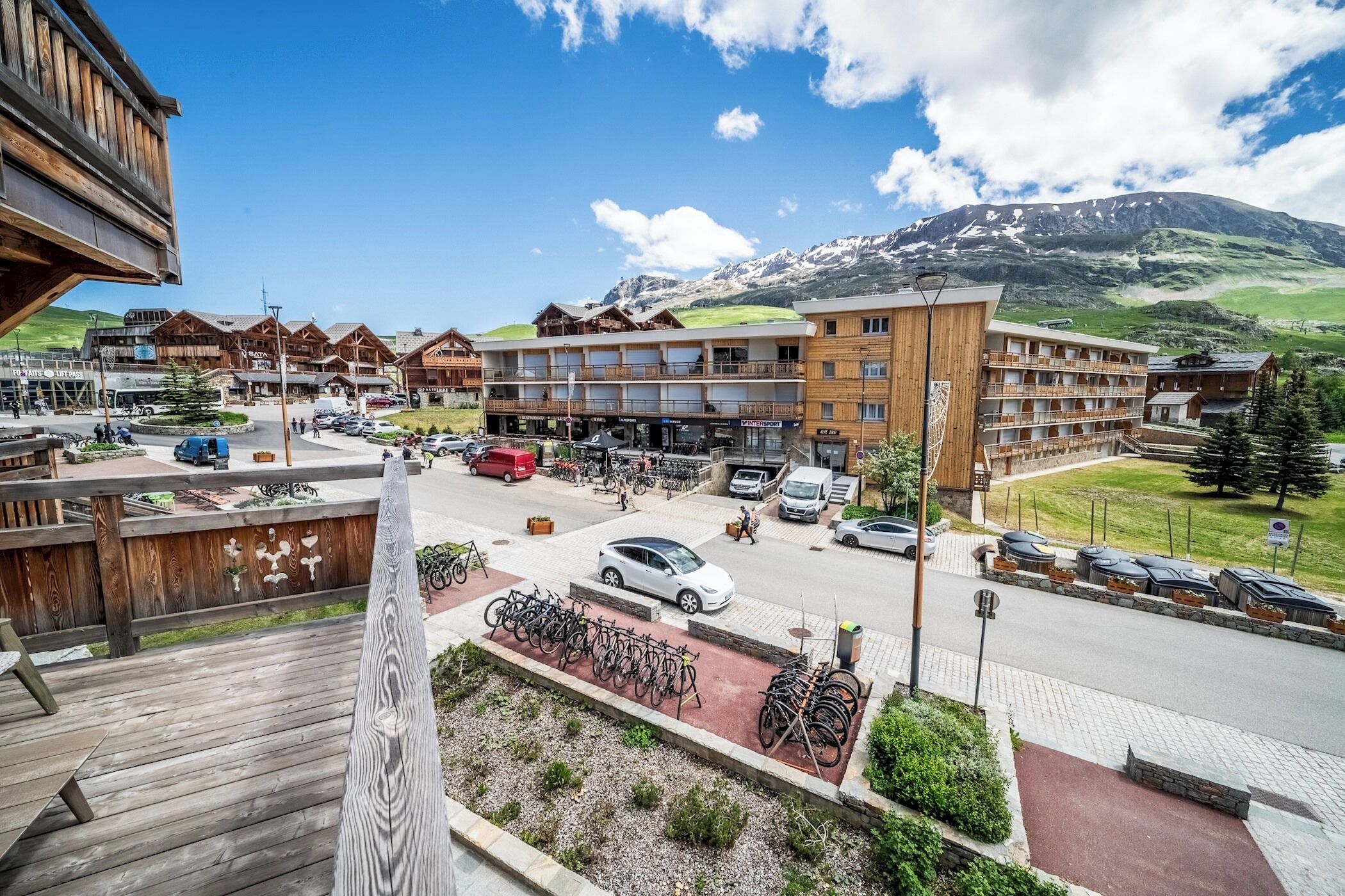 Un hôtel à plusieurs étages, doté d’une terrasse et offrant une vue sur la montagne.