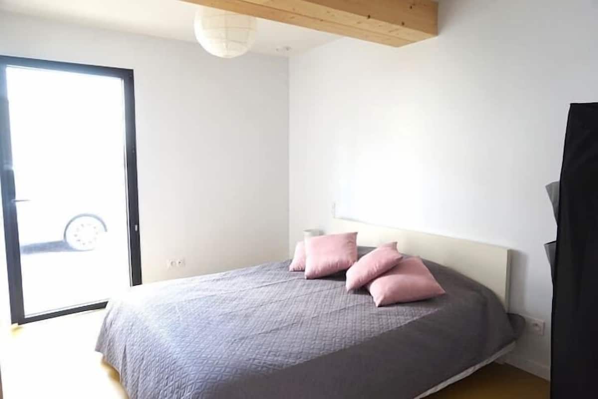 Un dormitorio con cama, ventana y puerta.