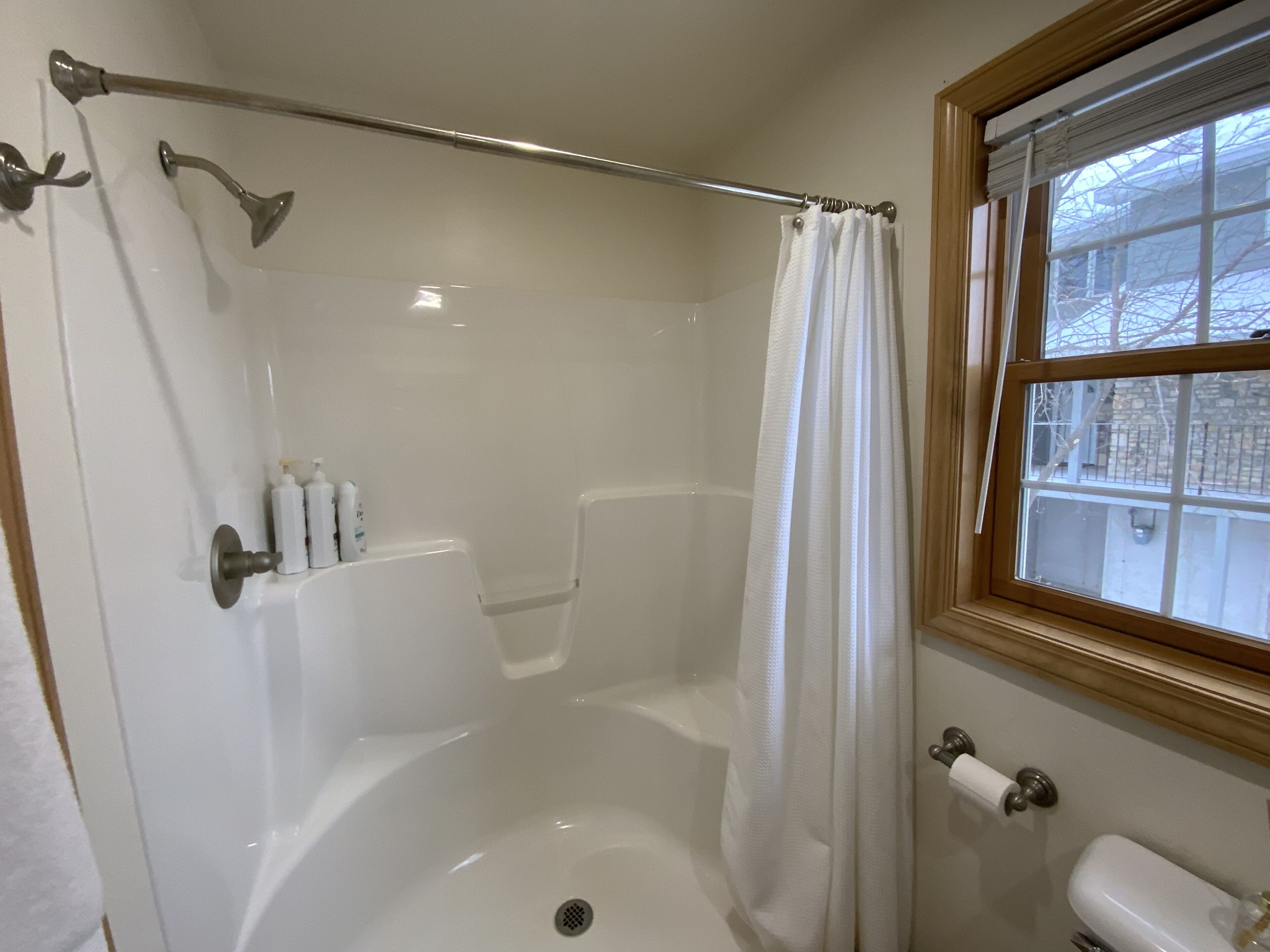 A bathroom with a bathtub, shower, and toilet.