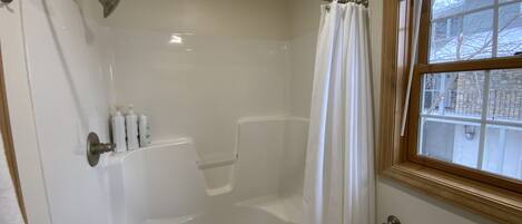 A bathroom with a bathtub, shower, and toilet.