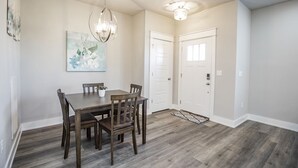 A dining area with a wooden table and chairs, a chandelier, and a painting on the wall. - Close to everything, New Fayetteville Home! (Fayetteville)