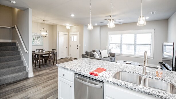 A modern kitchen with granite countertops, stainless steel appliances, and pendant lighting. - Close to everything, New Fayetteville Home! (Fayetteville)