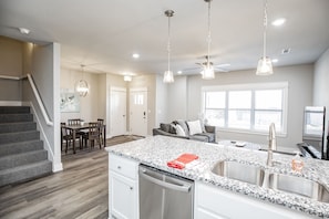 A modern kitchen with granite countertops, stainless steel appliances, and pendant lighting. - Close to everything, New Fayetteville Home! (Fayetteville)