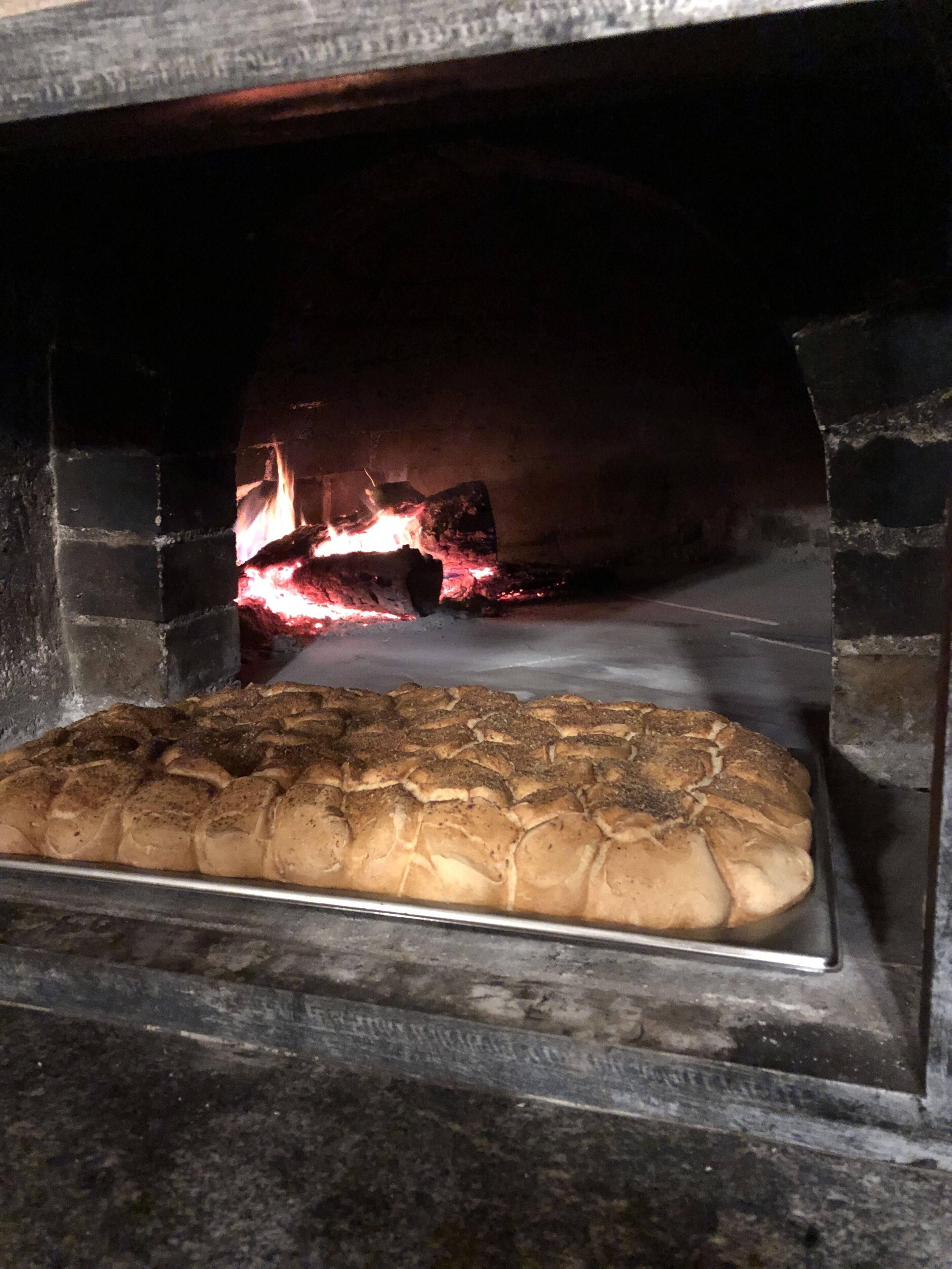 Un four en briques avec une plaque de cuisson à l’intérieur.