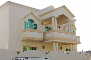 Stunning multi-story building with a central entrance and symmetrical facade, featuring balconies and grid-patterned windows.