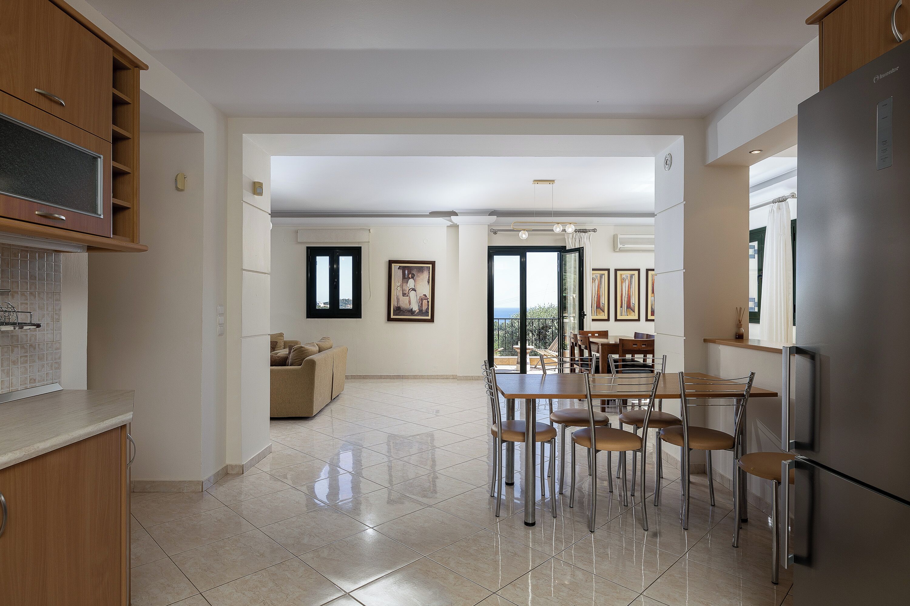 Una cocina moderna con comedor, un refrigerador grande y vistas al exterior.