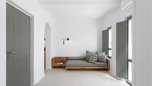 A narrow hallway with a built-in bench, a wall-mounted lamp, and large windows on one side. - Alio Suites-Suite N2 with private swimming pool (Νάξος)