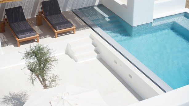 A modern pool area with two lounge chairs and a small tree. - Alio Suites-Suite N2 with private swimming pool (Νάξος)