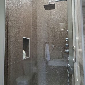 Een bad/douchecombinatie, handdoeken, toiletpapier