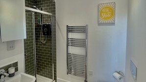 Une salle de bain moderne équipée d’une douche, de toilettes et d’un lavabo.