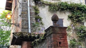 Ein rustikales Gebäude mit Steinaußenwand, Holzläden und einem traditionellen Ziegeldach.