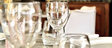 Una mesa con varios vasos de vino vacíos y un tenedor.