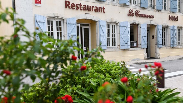 Un edificio con un letrero que dice "Restaurant Le Commerce Hôtel".