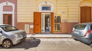 A building with a yellow facade, a wooden door, and a window. - Casa Conchiglia by BarbarHouse (Gallipoli)