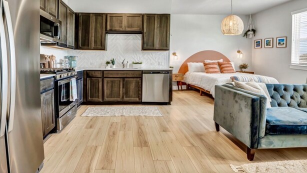 A modern kitchen with wooden cabinets, stainless steel appliances, and a herringbone tile backsplash. - Cozy Secluded Studio With Full-Kitchen, Washer And Dryer - The Works! (Austin)