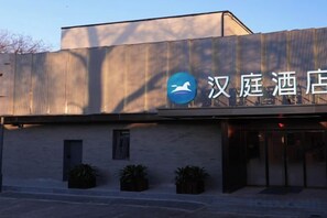 A hotel with a modern facade, a prominent logo, and a set of double doors. - HanTing Hotel (Beijing Xidan Mall) (Beijing)