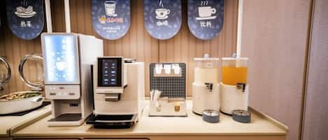 Een koffiehoek met een koffieapparaat, een melkopschuimer en een koffiepers.