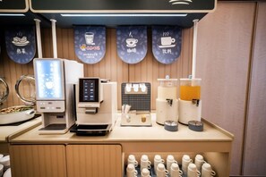 A coffee station with a coffee machine, a milk frother, and a coffee press.