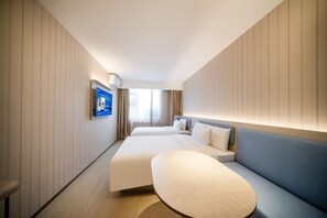 A hotel room with a large bed, a sofa, a TV mounted on the wall, and a window with curtains. - HanTing Hotel (Beijing Xidan Mall) (Beijing)