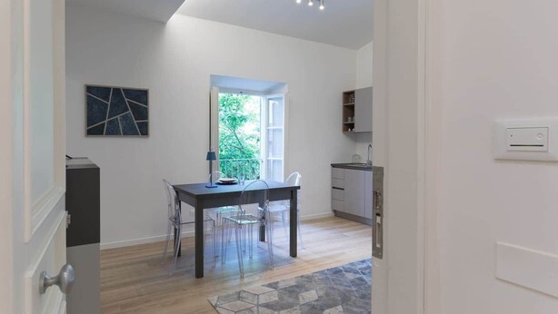 A modern kitchen with a built-in oven, a window, and a small island with a sink.