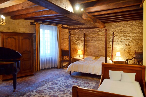A traditional room with a four-poster bed, a wooden wardrobe, and a piano. - A Gîte Full of Character (Flavigny-sur-Ozerain)