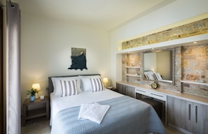 Relax in a stylishly appointed room with a large bed, bedside table, and decorative art piece.