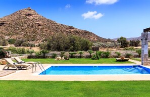 Relax by the pool surrounded by a lush lawn and mountain views.