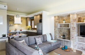 Enjoy a spacious living area with a kitchen, dining space, and mounted TV.