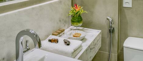 A bathroom with a sink, mirror, towel rack, and shower.