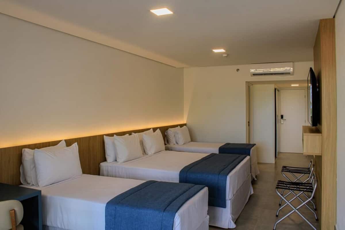 Een hotelkamer met twee bedden, een televisie en een klein bureau.