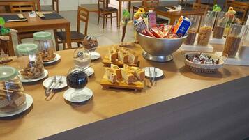 Una mesa de buffet con diversos alimentos y recipientes.