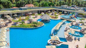 A resort with multiple swimming pools, sun loungers, and umbrellas.