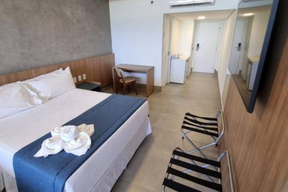 Een hotelkamer met een bed, een bureau en een stoel.
