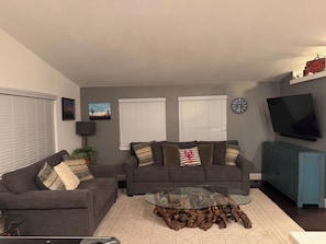 Relax in this stylish living room with two sofas, a flat-screen TV, and a glass coffee table.