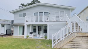 A two-story house with a front porch, a covered patio, and a wooden deck. - Murrells inlets #A Great duplex walk to the beach (Murrells Inlet)