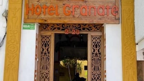 L’entrée de l’hôtel Granate se distingue par sa façade en bois, ses piliers décoratifs et une enseigne placée au-dessus de la porte.