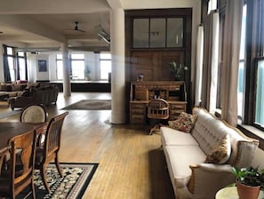Relax in a spacious living area with a high ceiling, sofa, and dining table.